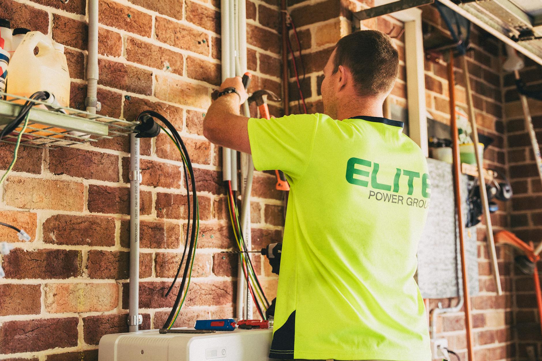 electrician installing grounding rod in soil